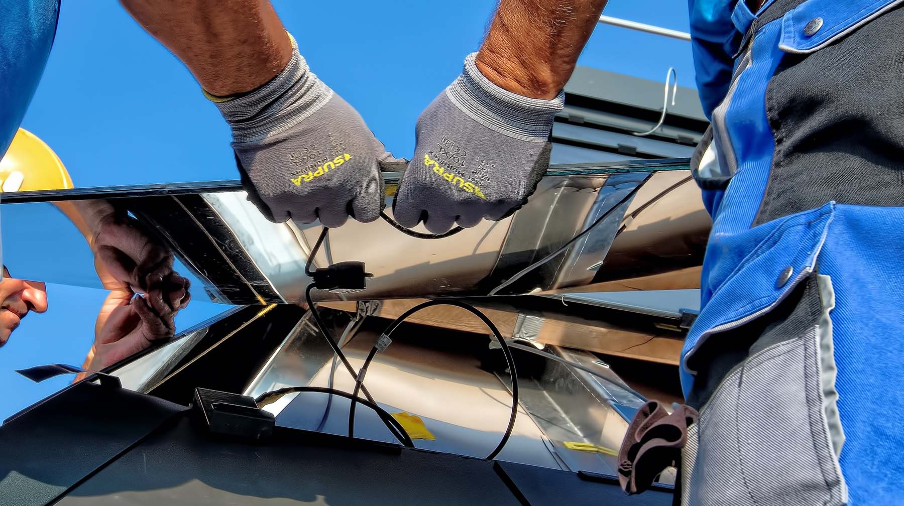 close up on the gloves of solar installers as they handle equipment